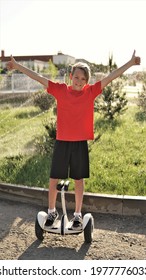 Happy Teenager Blond Boy On Segway Doing Thumbs Up