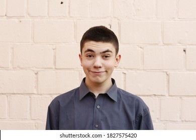 Happy Teenager Boy Grimace Wink Close Up Portrait On White Wall Background