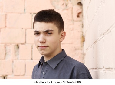 Happy Teenager Boy Wink Close Up Portrait On White Wall Background