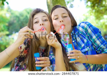 Happy teenager having fun with soap bubbles