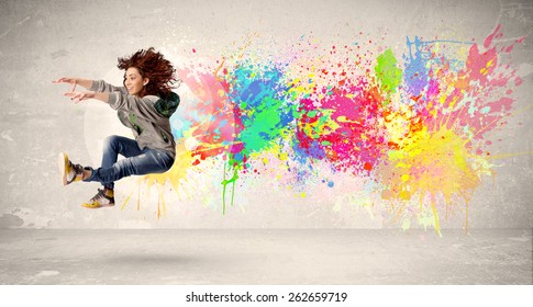 Happy Teenager Jumping With Colorful Ink Splatter On Urban Background Concept