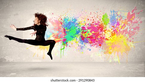 Happy Teenager springt mit buntem Tintenfleck auf städtischem Hintergrund