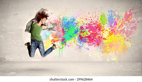 Happy Teenager Jumping With Colorful Ink Splatter On Urban Background Concept