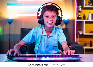 Happy Teenager Kid With Headphones Playing Live Video Game By Looking At Camera At Home - Concept Of Championship, Weekend Holidays And Live Streamer