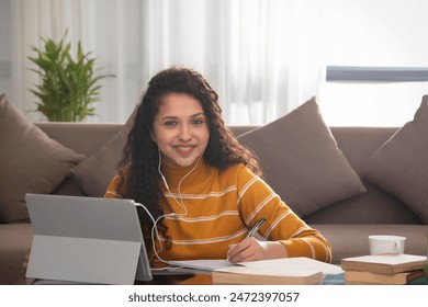 A HAPPY TEENAGER LOOKING AT CAMERA DURING ONLINE CLASS - Powered by Shutterstock