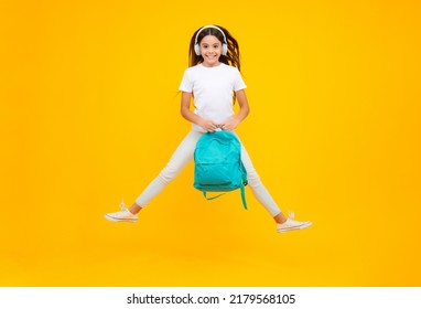 Happy teenager portrait. Back to school. Schoolgirl student in headphones with school bag backpack on isolated studio background. School and education concept. Jump and run, jumping child. - Shutterstock ID 2179568105