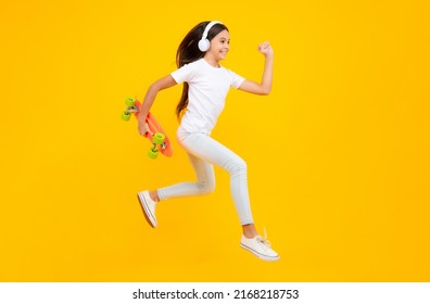 Happy Teenager Portrait. Studio Shot Of Trendy Teenage Fashion Model In Casual Look. Teenager Youth Hipster Urban Lifestyle. Jump And Run. Child Girl In Street Style In Hipster Clothes With A