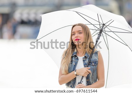 Happy teenager tourist girl visiting the city with a big white umbrella. Tourism and holidays theme.