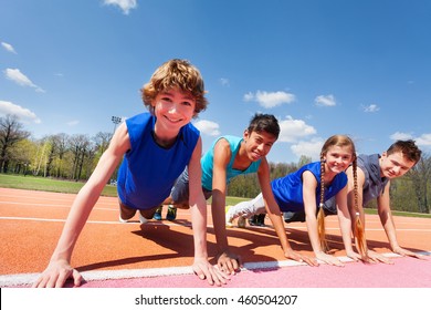 Happy teenagers holding plank outdoor on the track