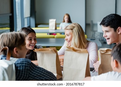 happy teenagers talking in school eatery while depressed girl sitting alone on blurred background
