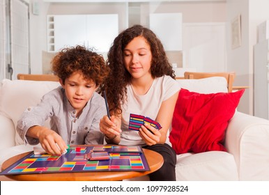 Happy Teens Playing Table Game Together At Home