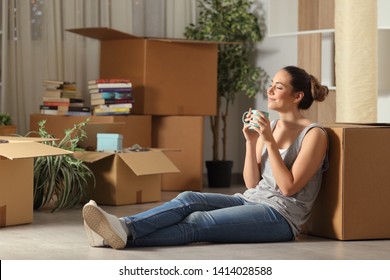 Happy tenant moving home resting breathing fresh air sitting on the floor in the night - Powered by Shutterstock