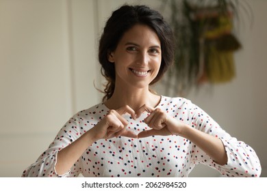Happy thankful Hispanic woman making finger heart shaped hand gesture, showing love sign, expressing, support, gratitude, solidarity, promoting donation charity campaign. Head shot portrait - Shutterstock ID 2062984520