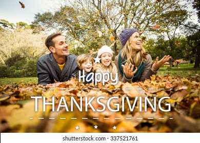 Happy Thanksgiving Against Smiling Young Family Throwing Leaves Around