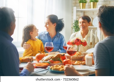 Happy Thanksgiving Day! Autumn Feast. Family Sitting At The Table And Celebrating Holiday. Grandparents, Mother, Father And Child. Traditional Dinner.