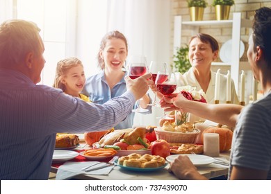 Happy Thanksgiving Day! Autumn Feast. Family Sitting At The Table And Celebrating Holiday. Grandparents, Mother, Father And Child. Traditional Dinner.