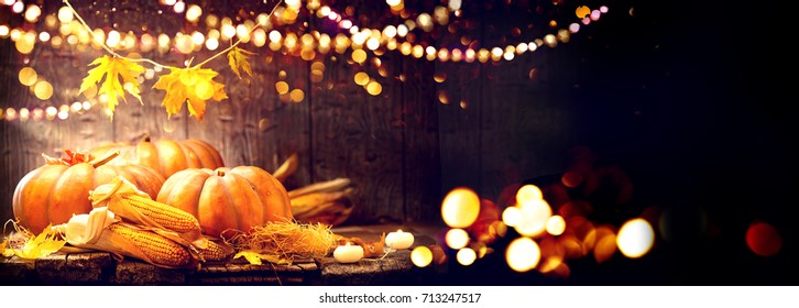 Happy Thanksgiving Day background, wooden table decorated with Pumpkins, Corncob, Candles and garland. Halloween. Beautiful Holiday Autumn festival concept scene Fall, Harvest