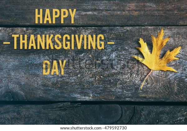 Happy\
Thanksgiving Day. Maple leaf on wooden\
background