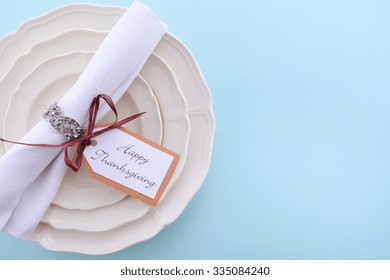 Happy Thanksgiving Formal Table Place Setting With Fine China And Vintage Napkin Ring On Pale Blue Wood Table. 