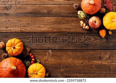 Happy Thanksgiving holiday banner design. Ripe orange pumpkins, apples, red berries in corners on dark wooden table.