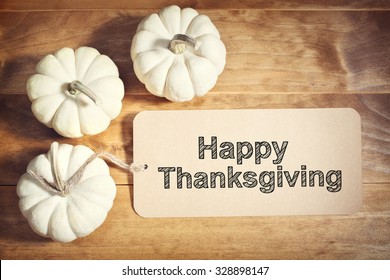 Happy Thanksgiving Message With Small White Pumpkins On Wooden Table