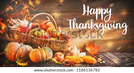 Happy Thanksgiving. Pumpkins with fruits and falling leaves on rustic wooden table