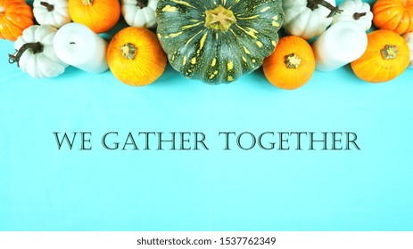 Happy Thanksgiving Setting Modern Elegant Blue Orange And White Themed Table With Pumpkins Centerpiece Overhead Flat Lay With We Gather Together Text Message Greeting.