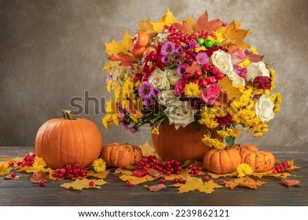 happy thanksgiving still life. autumn flowers roses, chrysanthemums, asters in a pumpkin vase.