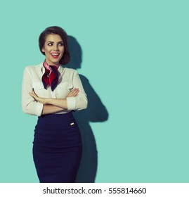 Happy Thinking Woman Looking To The Left. Young Beautiful Hostess With Big Smile On Blue Background.