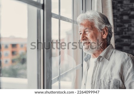 Happy thoughtful older 70s man looking out of window away with hope, thinking of good health, retirement, insurance benefits, dreaming of future. Elderly pensioner waiting meeting with family Foto stock © 
