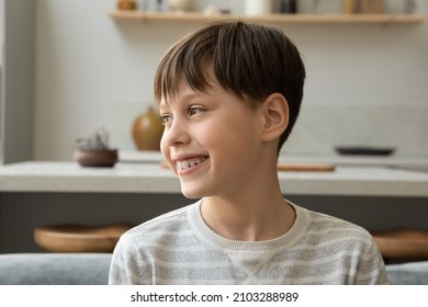 Happy thoughtful teenage boy with dental braces, smiling at good thoughts. Positive teen schoolchild making video call from home, talking, laughing, looking away from camera. Candid head shot portrait