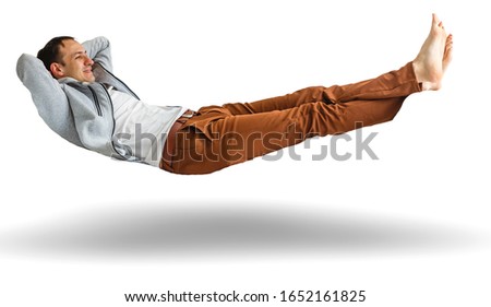 Happy thoughtful young man lying on the floor and looking up at copyspace