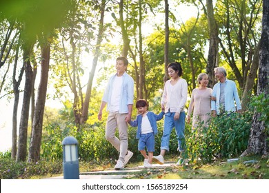 Happy Three Generation Asian Family With Mother Father Son Grandmother, Grandfather Walking Relaxing Outdoors In Park