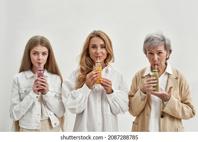 Happy Three Generations Of Women Isolated On White Studio Background Drink Fruit Sugar Free Juices Or Smoothies. Smiling Girl Child With Mother And Grandmother Follow Healthy Life. Diet, Detox.