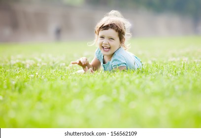 Happy Three Year Old Child Playing  At Grass Meadow In Summer