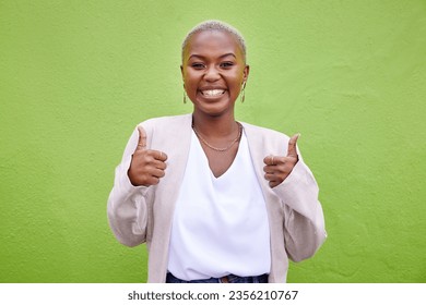 Happy, thumbs up and portrait of black woman by a green wall with classy and elegant jewelry and outfit. Happiness, excited and African female model with positive and confident attitude with fashion.
