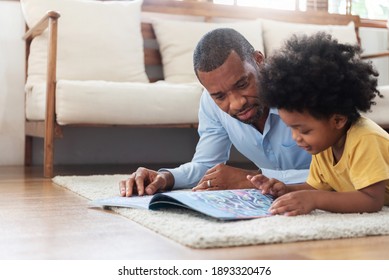 Happy time of African family. African-American Father lying reading book on the floor with his son before traveling to work at living room. Parenthood and childhood concept. - Powered by Shutterstock