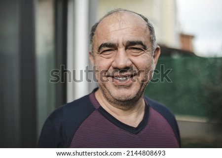 Happy and tired middle eastern man looking at the camera selective focus outdoor real people portrait