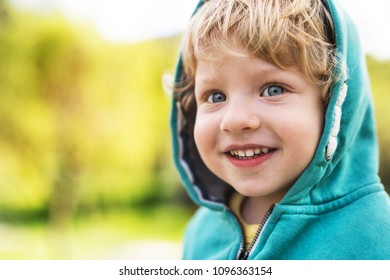 A Happy Toddler Boy Outside In Spring Nature. Close Up.