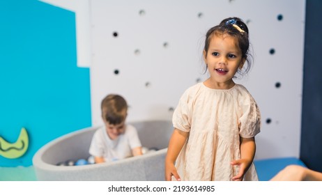 Happy Toddler Boy Playing In A Ball Pit Full Of Colorful Balls. Sensory Play At The Nursery School For Kids Wellness. High Quality Photo