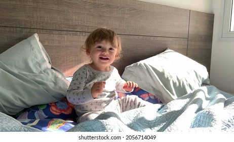 Happy Toddler Boy Playing Peekaboo, Baby Plays Hide And Seek Under Bed Blankets