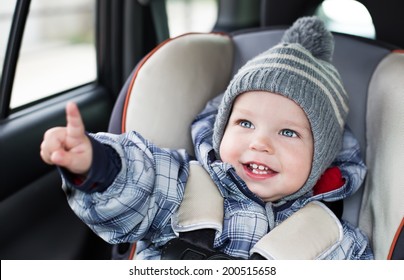 Happy Toddler  Boy Sitting In The Car Seat 