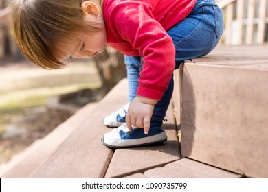 Happy Toddler Boy Tying His Sneakers Outside