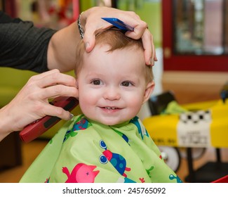 Happy toddler child getting his first haircut