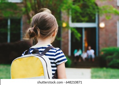 Happy Toddler Girl Arriving Home From School With A Backpack