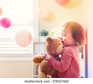 Happy Toddler Girl Playing With Her Teddy Bear At House