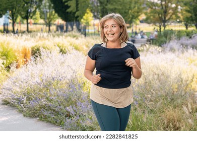 Happy and toothy smile woman jogging, sporty woman running outdoor, body positive and healthy lifestyle concept - Powered by Shutterstock