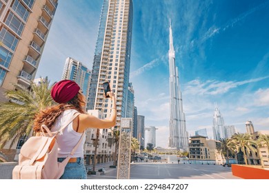 happy tourist asian girl taking photos for her travel blog, in Dubai downtown district against background of the grandiose Burj Khalifa highest skyscraper in the world - Shutterstock ID 2294847207