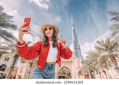 happy tourist asian girl taking selfie photos for her travel blog, in Dubai downtown - Shutterstock ID 2298151205