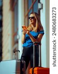 
Happy Tourist Checking her Phone After Arriving at her Destination. Travel girl searching directions and booking hotels 
